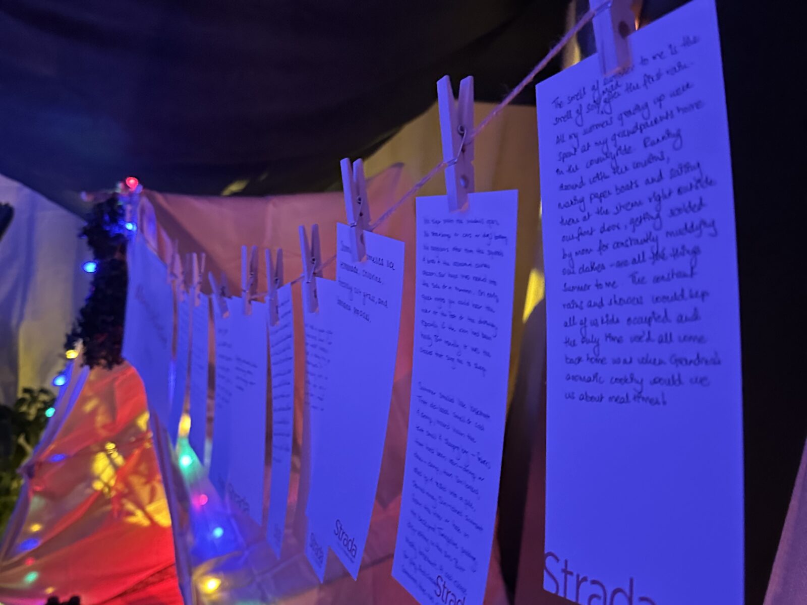 paper clothespinned to a line in a dark room. the paper has writing on it reflective of the questions in the article